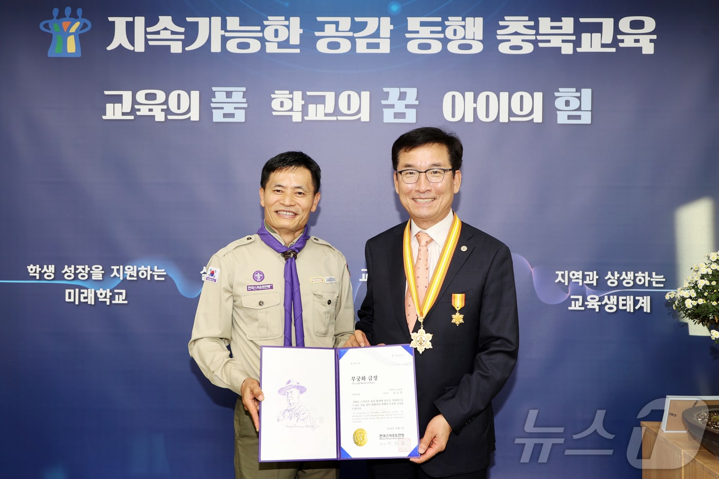 윤건영 충북교육감이 11일 신성식 한국스카우트충북연맹장으로부터 한국스카우트연맹 최고 훈장인 무궁화 금장을 전달받았다.(충북교육청 제공)/뉴스1
