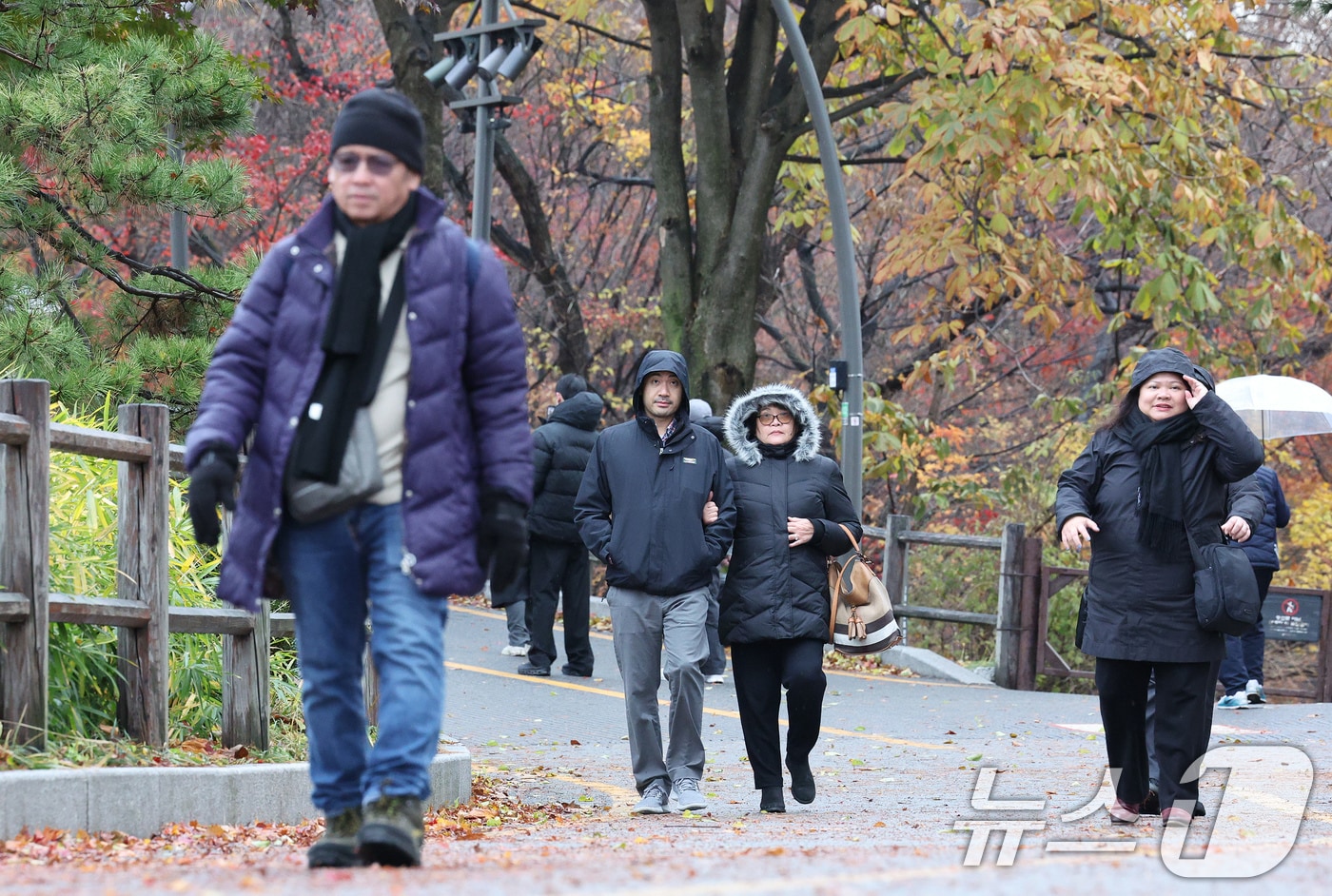 26일 오전 서울 중구 남산을 찾은 외국인 관광객들이 두꺼운 옷을 껴입고 있다. 기상청은 이날 전국에 비와 함께 강한 바람이 불다가 새벽에는 수도권에 첫눈이 내릴 것으로 예보했다. 2024.11.26/뉴스1 ⓒ News1 장수영 기자