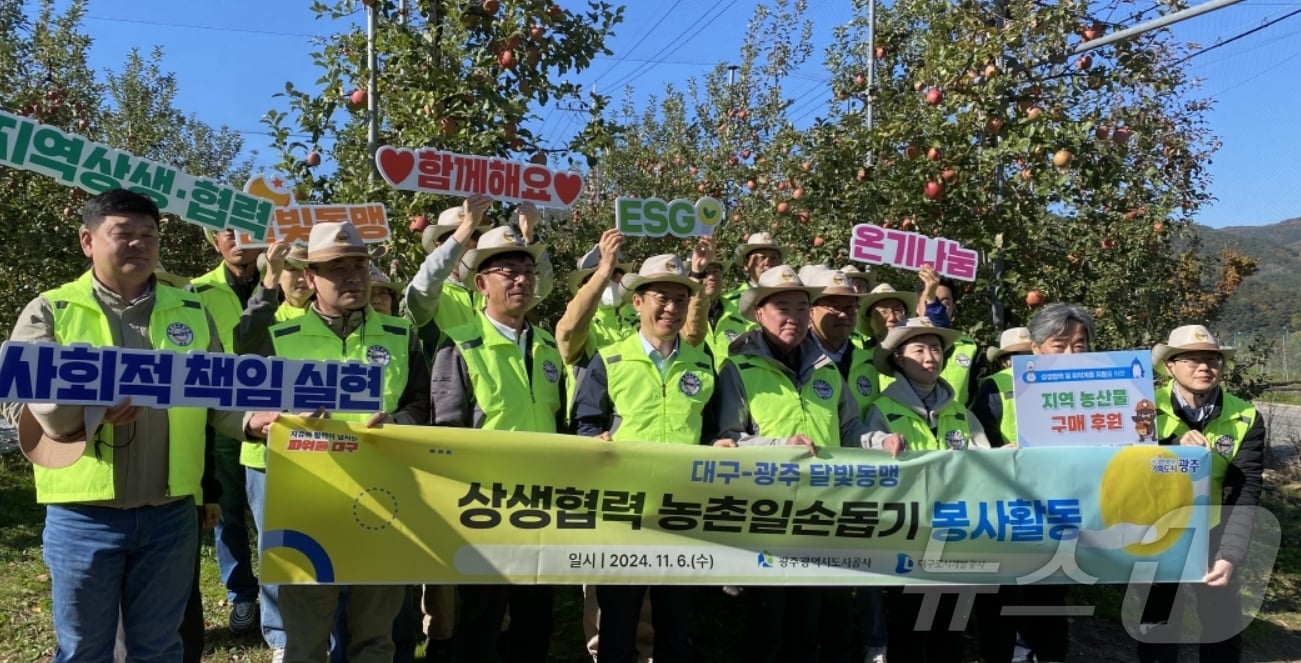 대구도시개발공사와 광주도시공사 임직원들이 6일 대구 군위군 부계면에서 달빛동맹 농촌일손돕기 봉사 활동을 펼친 뒤 기념사진을 찍고 있다.&#40;대구도시개발공사 제공&#41;