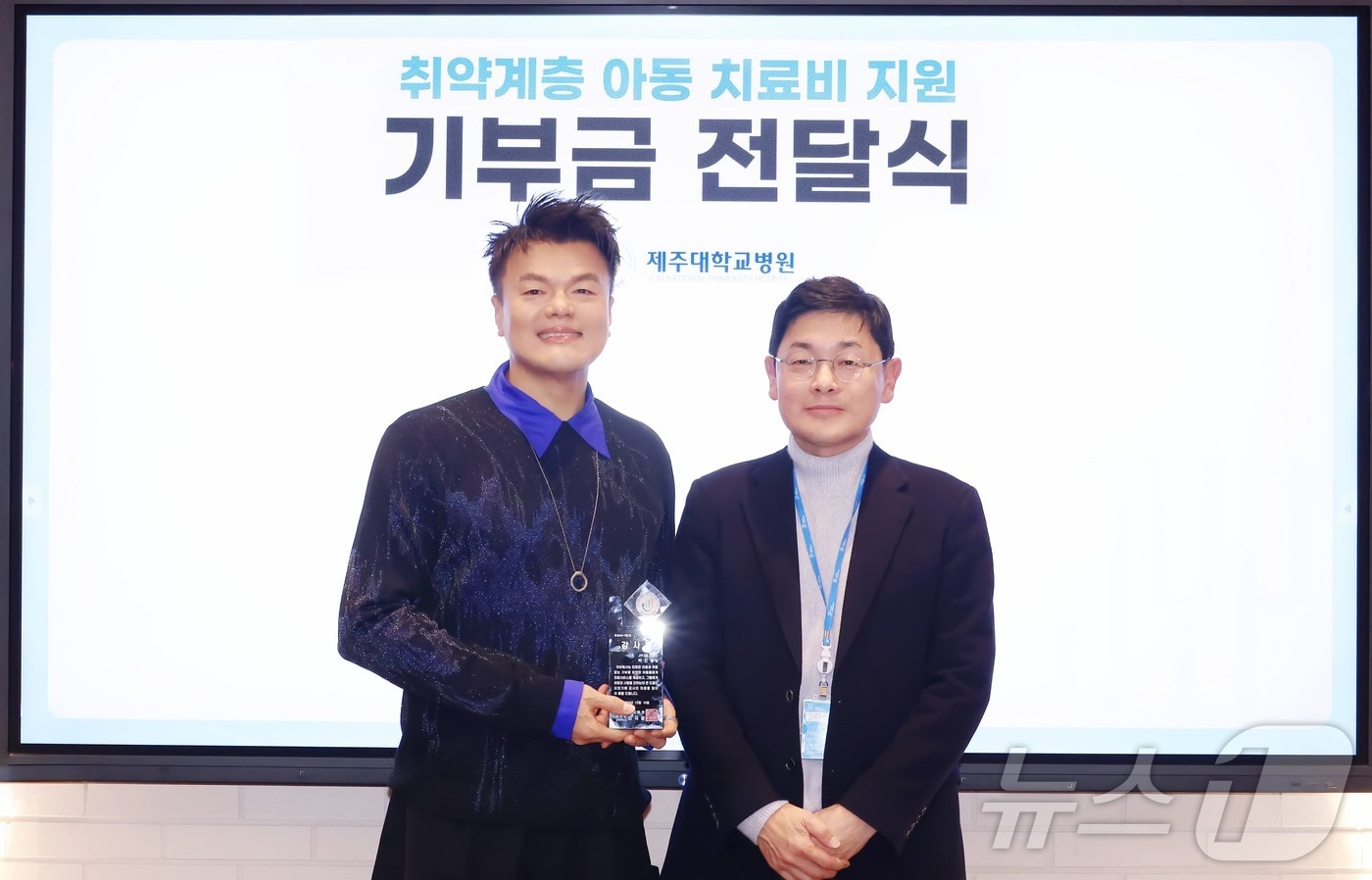 가수 겸 JYP엔터테인먼트 대표 프로듀서 박진영 씨가 지난 10일 서울 강동구 JYP 본사에서 제주대학교병원 발전후원회 본부장 최성욱 교수에게 기부금 2억원을 전달하고 있다.&#40;제주대학교병원 제공&#41;