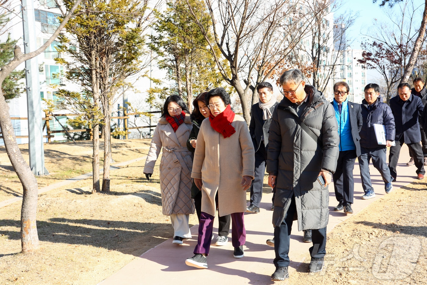 김경희 이천시장&#40;가운데&#41;이 18일 열린 온천공원 무장애 나눔 길 기념행사에서 참석자들과 함께 산책로를 걸으며 시설을 확인하고 있다.&#40;이천시 제공&#41;