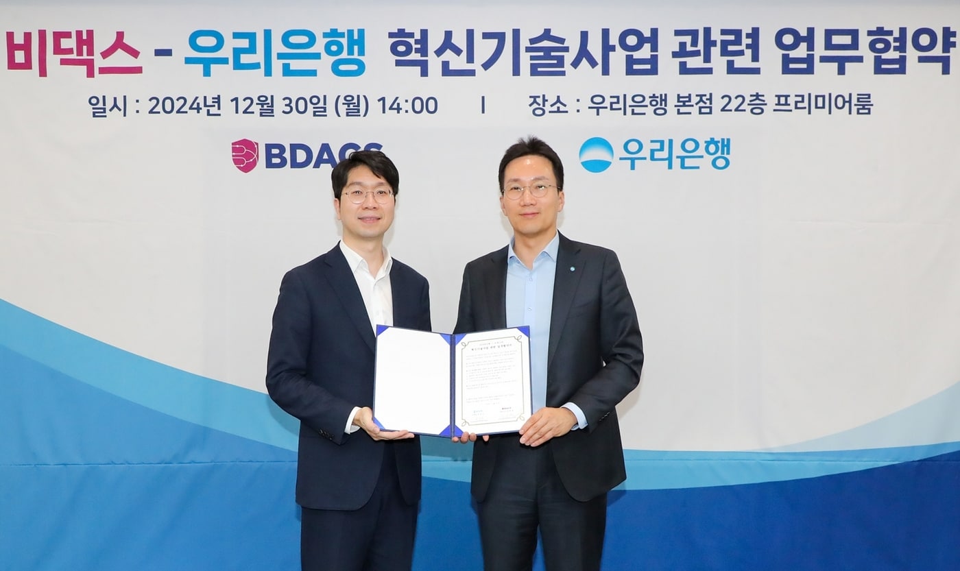 우리은행이 30일 은행 본점에서 비댁스와 혁신기술사업 관련 업무협약(MOU) 체결 후 (왼쪽부터) 류홍열 비댁스 대표, 옥일진 우리은행 디지털전략그룹장이 기념사진을 촬영하고 있다 (우리은행 제공)