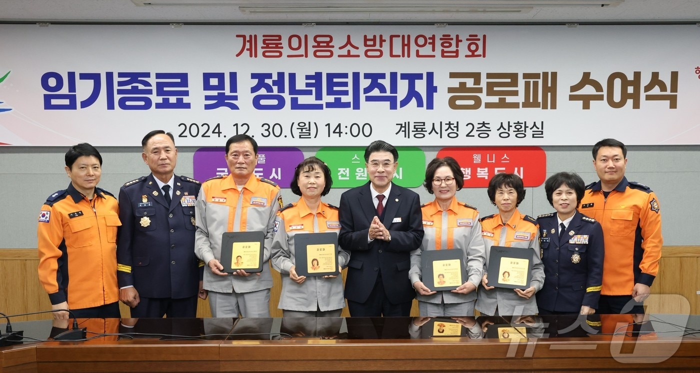 계룡의용소방대연합회 임기종료 및 정년퇴직자 공로패 수여식에서 참석자들이 기념촬영을 하고 있다. 가운데가 이응우 시장. &#40;계룡시 제공&#41; /뉴스1