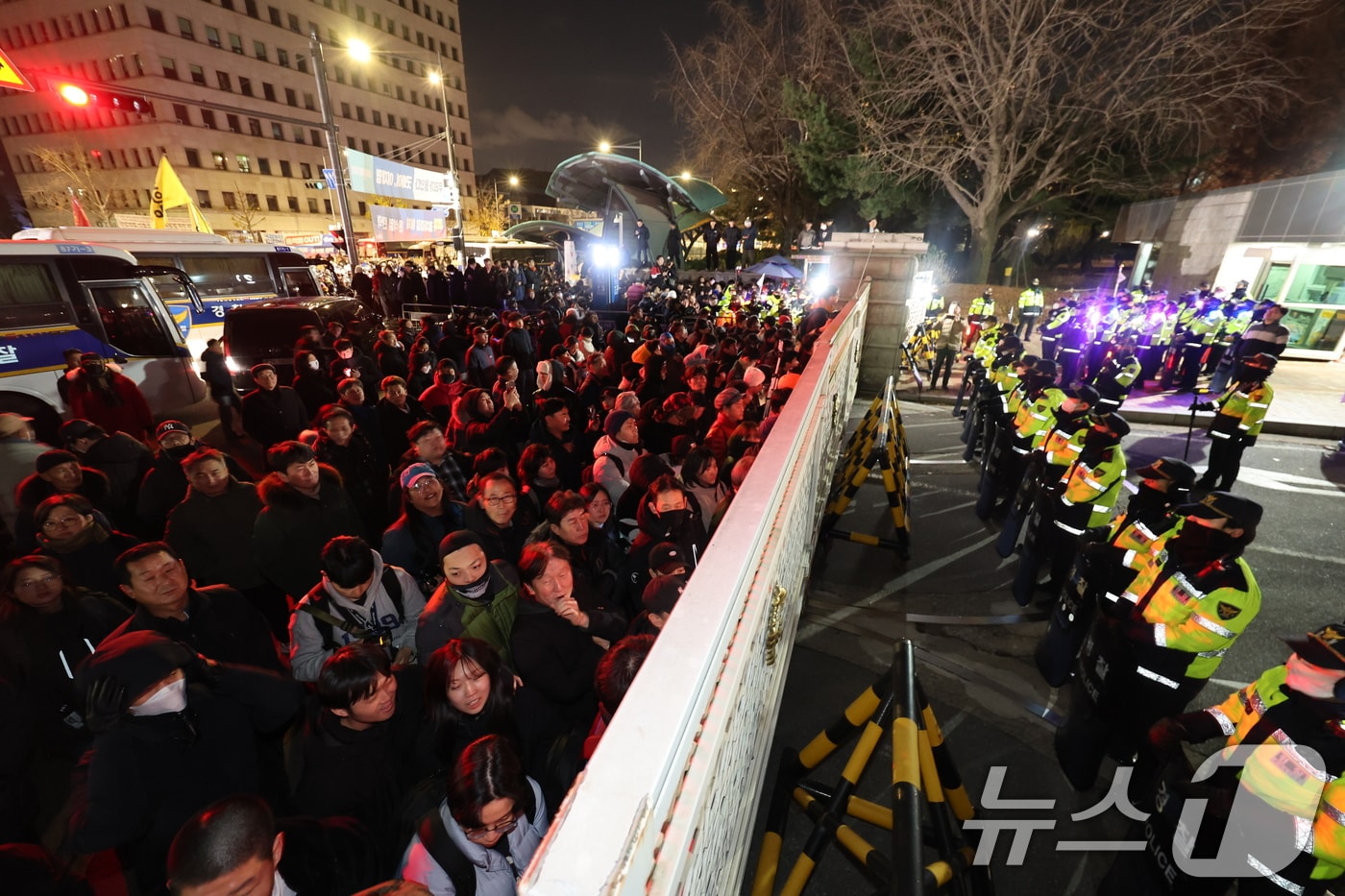 윤석열 대통령의 비상계엄 해제 요구 결의안이 국회 본회의에서 통과된 4일 새벽 서울 여의도 국회 정문 앞에 모인 시민들이 출입을 막고 있는 경찰 병력에게 국회 개방을 촉구하고 있다. 여야는 이날 본회의에서 재석 190명 중 찬성 190명으로 비상계엄 해제 요구 결의안을 가결 처리했다. 이에 따라 계엄령 선포는 무효가 됐다고 국회의장실은 설명했다. 2024.12.4/뉴스1 ⓒ News1 박지혜 기자