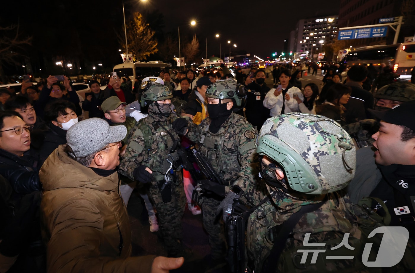 윤석열 대통령이 비상계엄령을 전격 선포한 가운데 4일 새벽 서울 여의도 국회 앞에서 시민들이 경내로 진입하려는 계엄군을 붙잡아 막아서고 있다. 2024.12.4/뉴스1 ⓒ News1 구윤성 기자