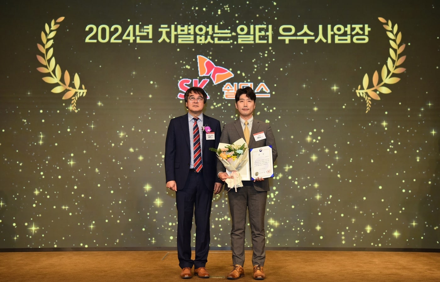 이달 5일 서울 용산구 피스앤파크컨벤션에서 열린 '2024년 차별 없는 일터 조성 우수사업장 시상식'에서 장민수 SK쉴더스 기업문화실 상무(오른쪽)와 김유진 고용노동부 노동정책실 실장(왼쪽)이 기념 촬영을 하고 있다.(SK쉴더스 제공)