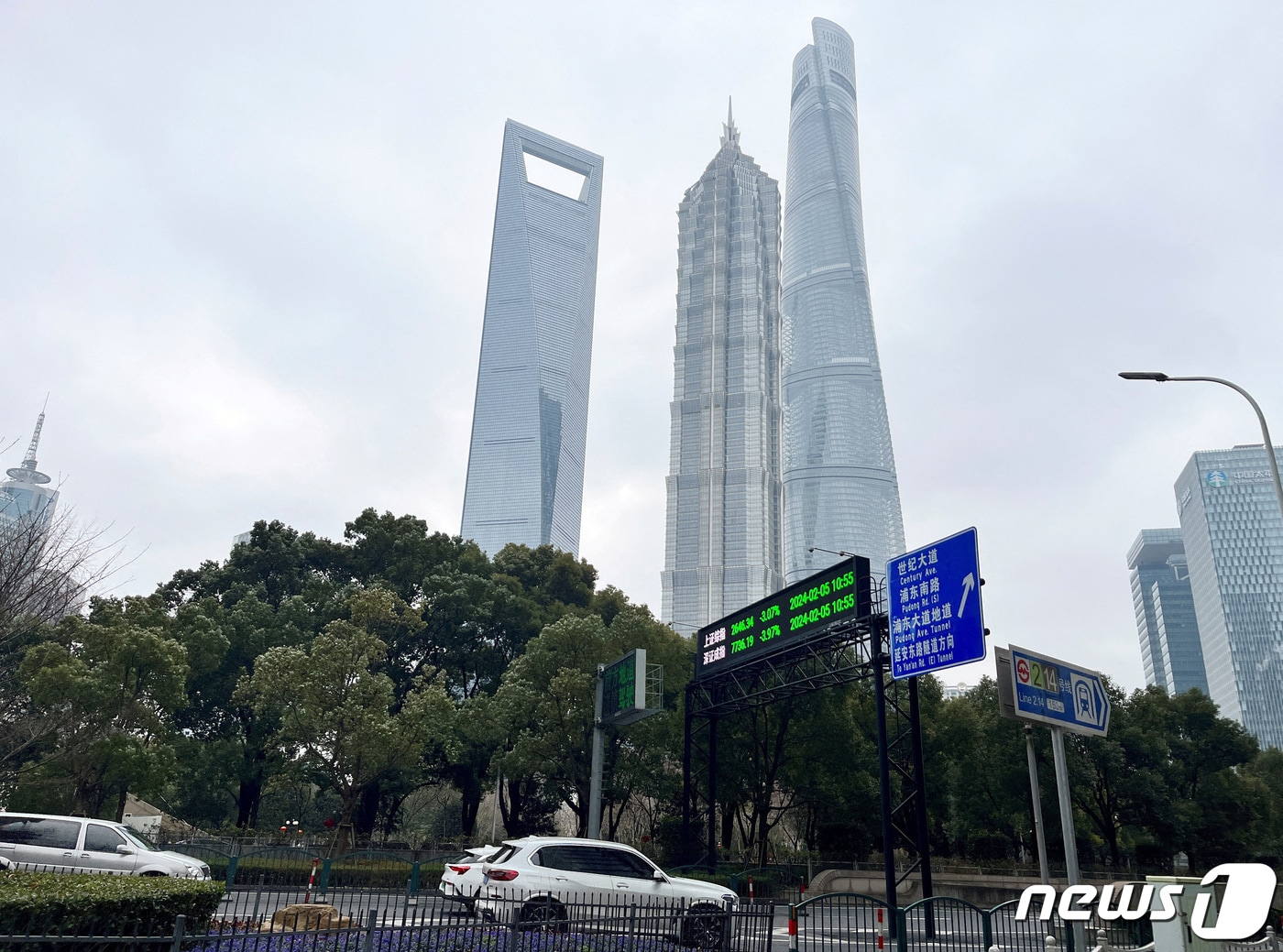 중국 상하이 루자주이 금융지구의 상하이 타워와 다른 고층 빌딩 근처에서 상하이와 선전 주가지수를 보여주는 전광판을 자동차들이 지나가고 있다. 2024.2.5 ⓒ 로이터=뉴스1 ⓒ News1 정은지 특파원