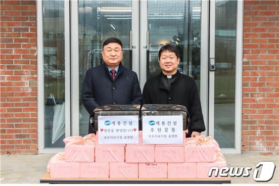 진중길 계룡건설 상무(왼쪽)가 김현 효광원 원장에게 위문품을 전달한 후 기념사진을 찍고 있다.(계룡건설 제공)/ 뉴스1 ⓒ News1