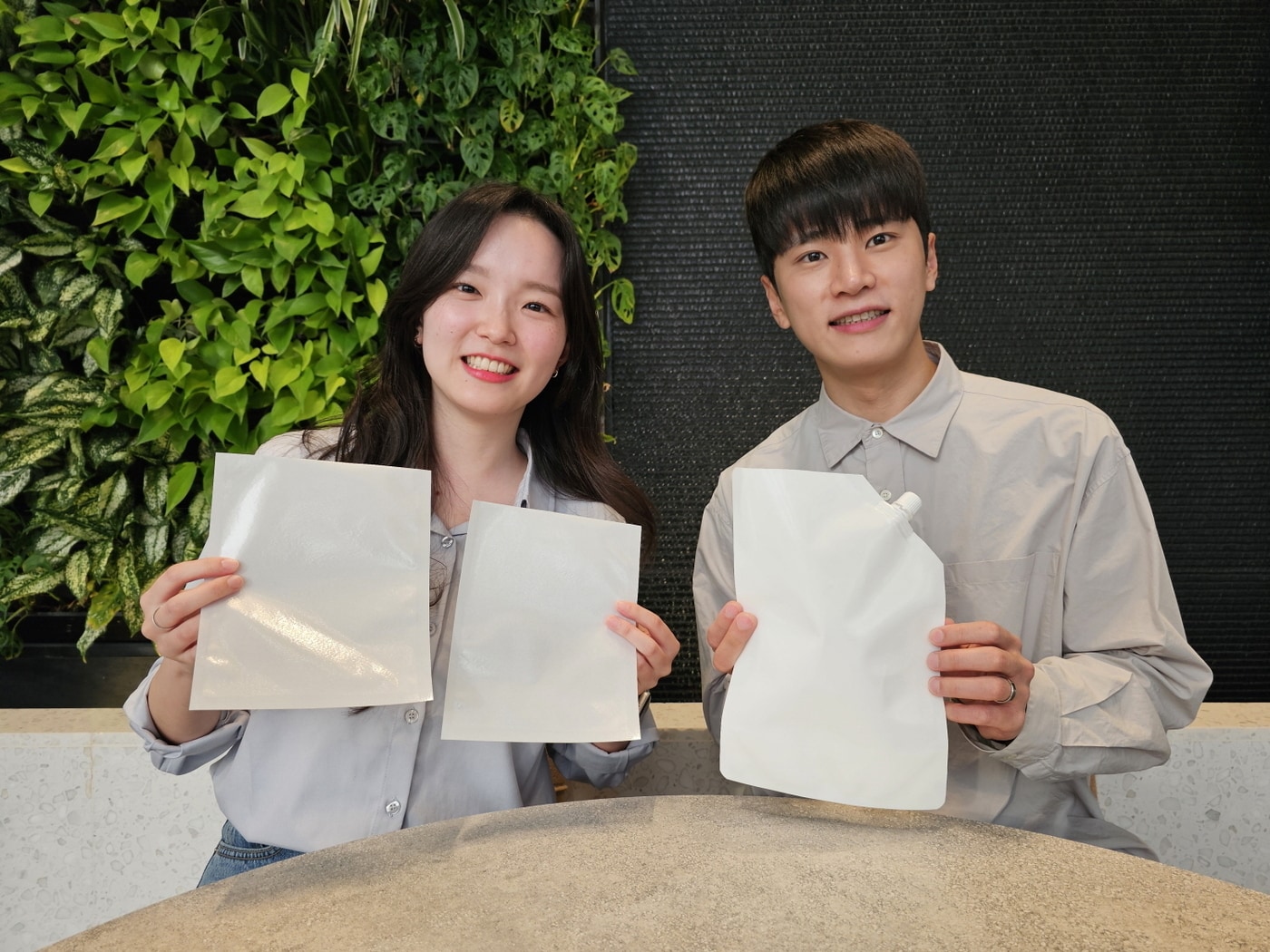 SK지오센트릭 구성원들이 SK지오센트릭의 단일 플라스틱 소재로 율촌화학이 제조한 포장재 시제품을 소개하고 있다.(SK지오센트릭 제공) 