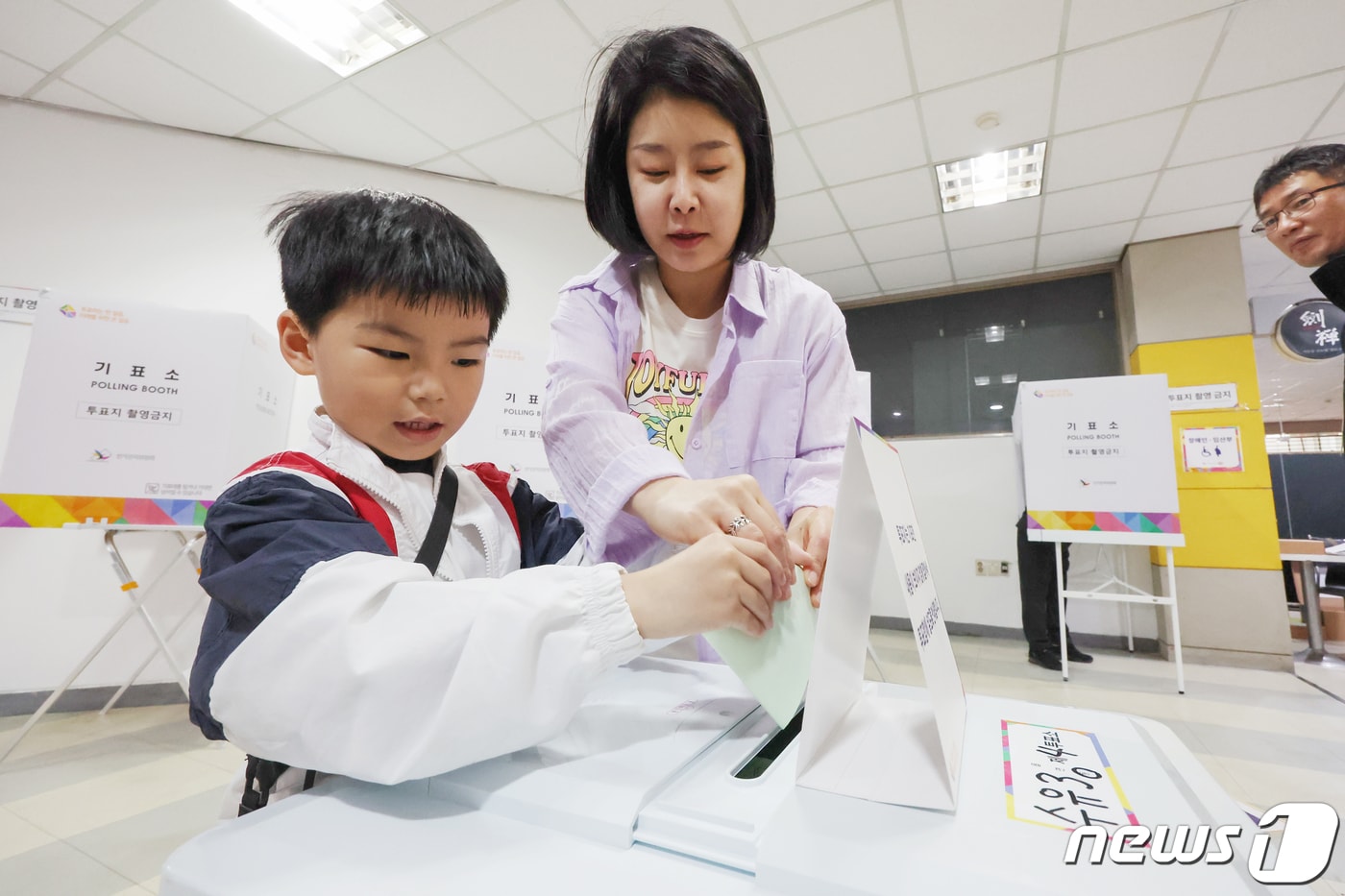 제22대 국회의원선거 투표일인 10일 서울 강북구 수유중앙시장 상가에 마련된 수유3동 제4투표소에서 한 유권자가 자녀와 함께 투표를 하고 있다. 2024.4.10/뉴스1 ⓒ News1 민경석 기자