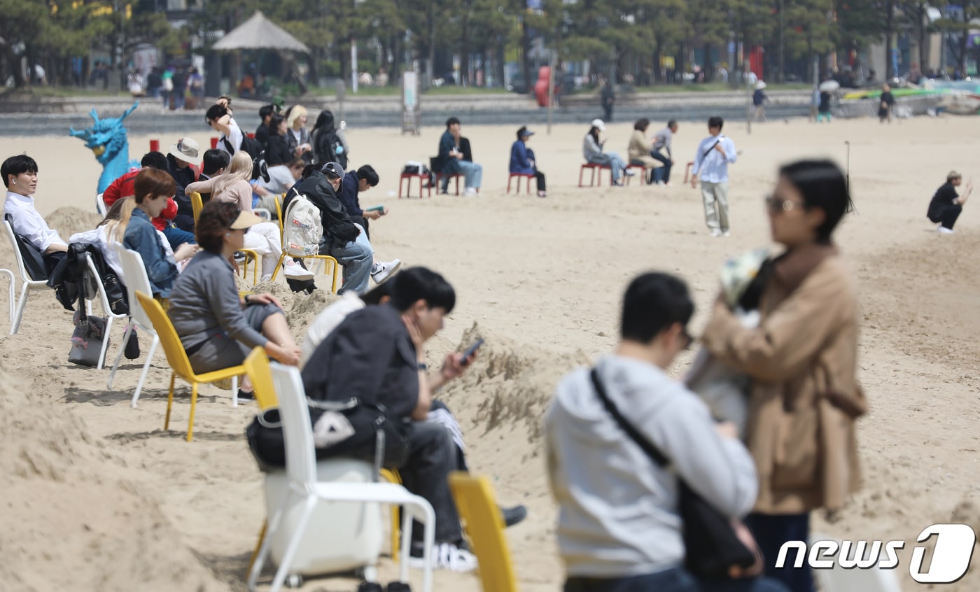 초여름 날씨를 보인 12일 오후 부산 수영구 광안리해수욕장을 찾은 시민 등 관광객들이 벤치에 앉아 휴식을 취하고 있다. 2024.4.12/뉴스1 ⓒ News1 윤일지 기자