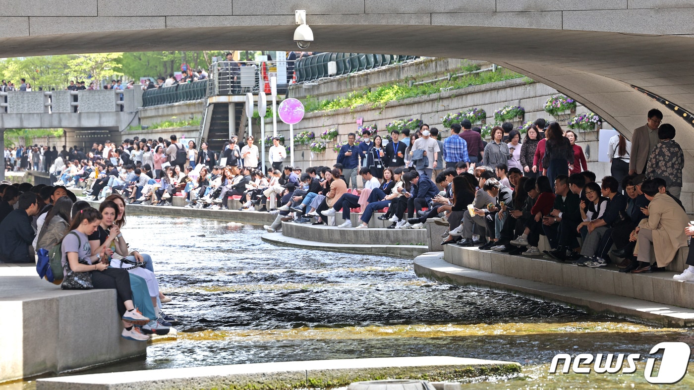 서울지역 낮 최고기온이 25도까지 오르며 초여름 날씨를 보인 지난 18일 오후 서울 중구 청계천을 찾은 시민과 관광객이 물가에 앉아 더위를 식히고 있다. 2024.4.18/뉴스1 ⓒ News1 장수영 기자