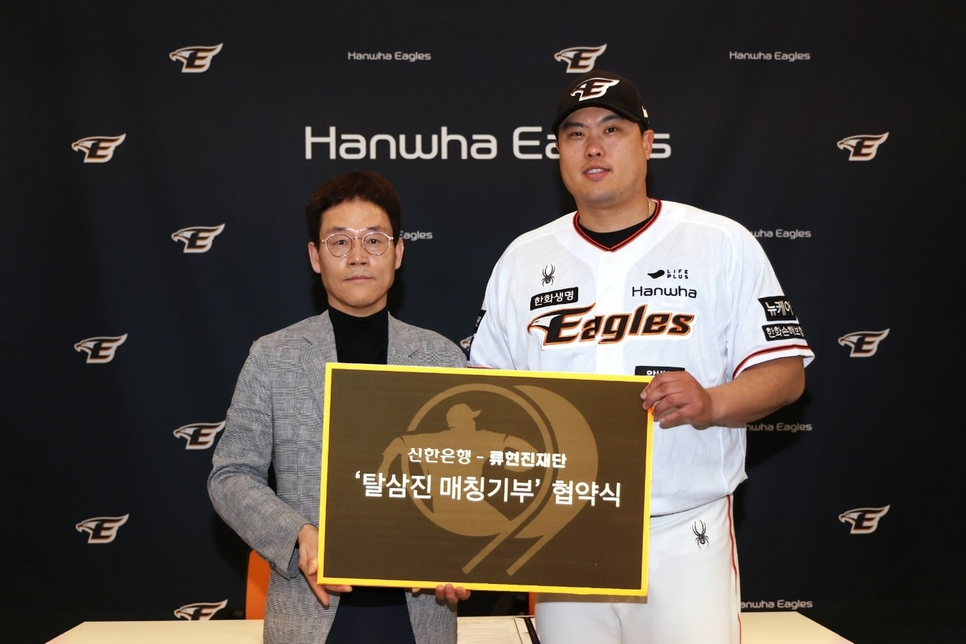 지난 26일 대전광역시 중구에 위치한 한화생명이글스파크에서 진행된 기부협약식에서 신한은행 대전 충남본부 송인조 본부장(왼쪽)과 류현진 재단 류현진 이사장이 기념 촬영하는 모습./사진제공=신한은행