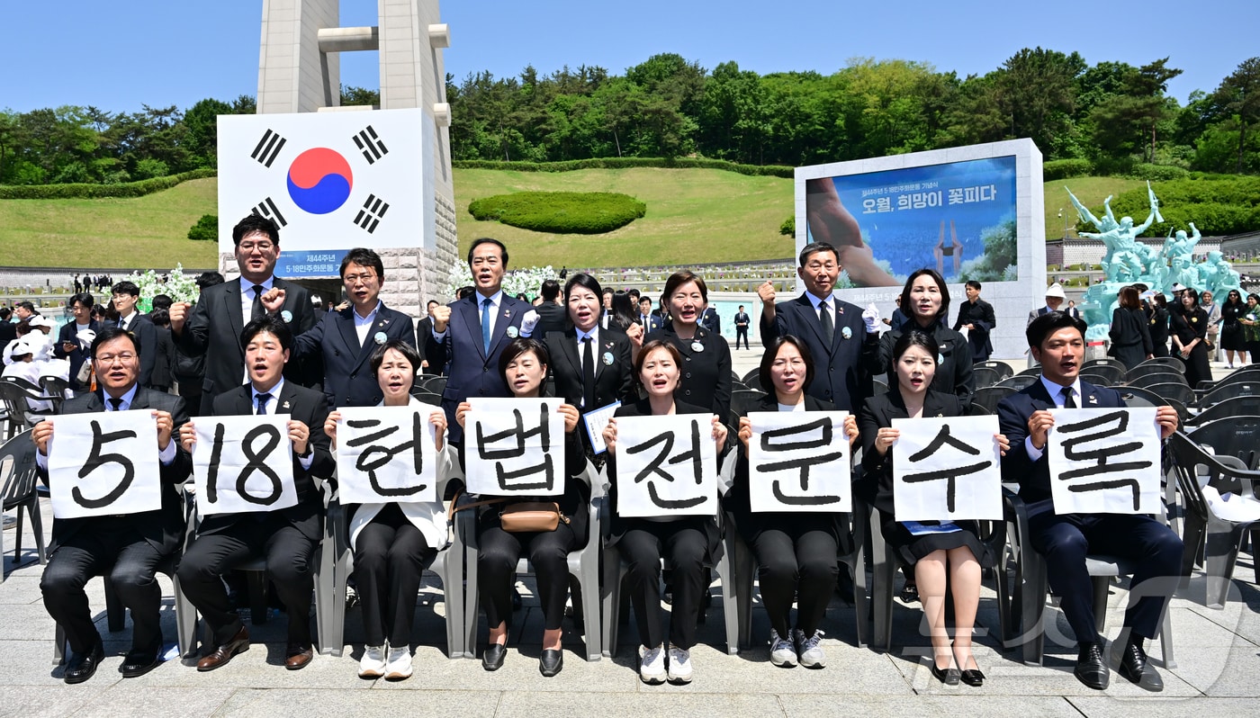 광주시의회 5·18특별위원회 위원들이 지난 2024년 5월18일 광주 북구 국립5·18민주묘지에서 5·18민주화운동 제44주년 기념식을 마친 뒤 '5·18 헌법 전문 수록'이라고 적힌 손팻말을 들고 있다. (공동취재) 2024.5.18 ⓒ 뉴스1 안은나 기자