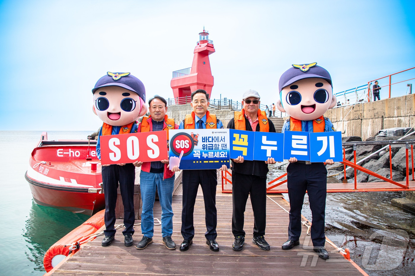 한상철 제주해양경찰청장(가운데)이 20일 제주시 이호테우해변에서 'SOS 구조버튼 누르기' 릴레이 챌린지에 참여하고 있다.(제주해양경찰청 제공)