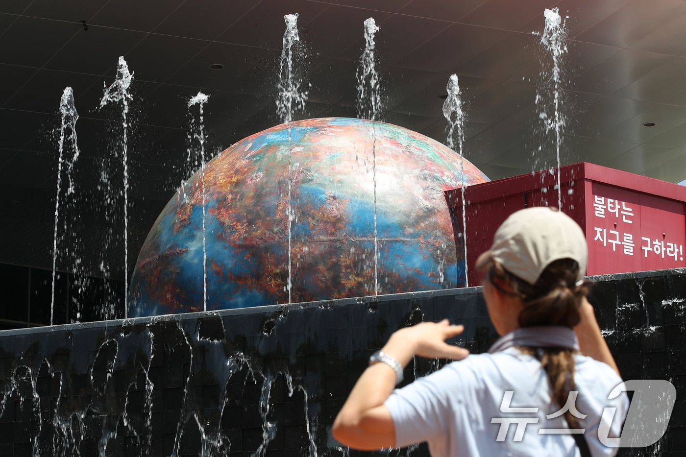 폭염이 기승을 부린 11일 대구 동구 팔공산 시민안전테마파크를 찾은 시민이 불타는 지구 조형물을 바라보고 있다. 2024.6.11/뉴스1 ⓒ News1 공정식 기자