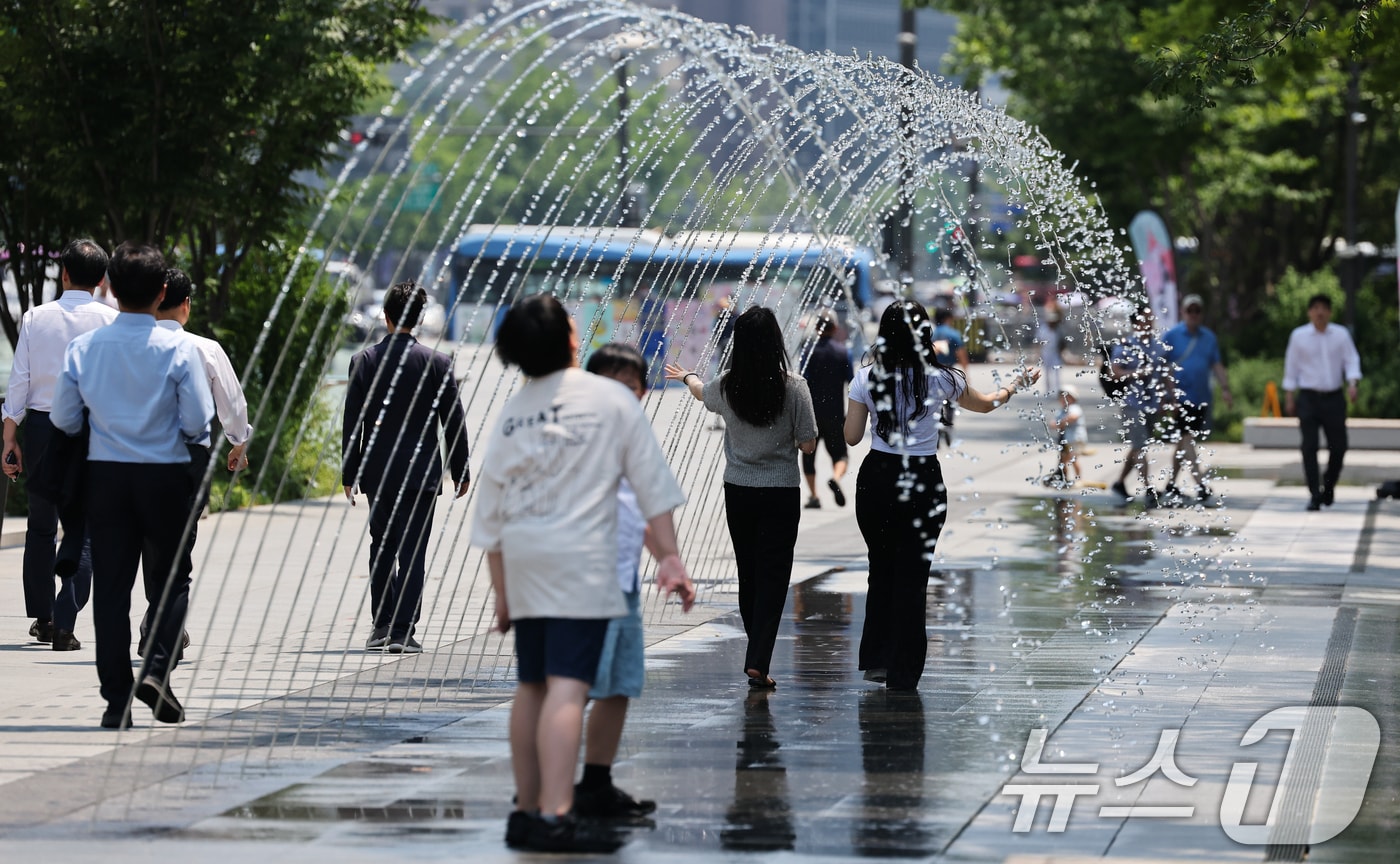 서울 낮 최고기온 32도 등 무더운 날씨를 보인 18일 광화문광장 터널분수에서 시민들이 더위를 식히고 있다. 2024.6.18/뉴스1 ⓒ News1 허경 기자