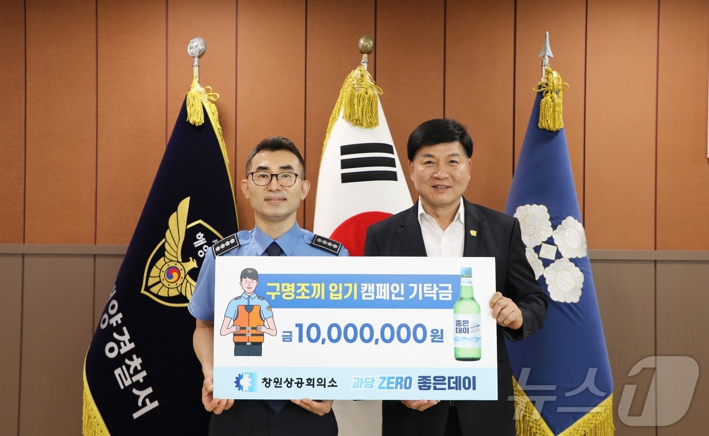 창원상의 회장인 최재호 무학 회장&#40;오른쪽&#41;이 김영철 창원해양경찰서 서장에게 &#39;구명조끼 입기 캠페인&#39;을 위한 성금을 전달하고 기념사진을 촬영하고 있다.&#40;창원상의 제공&#41;