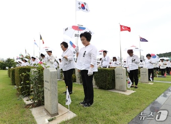 25일 부산 남구 유엔기념공원에서 열린 &#39;제74주년 6.25전쟁 참전 유엔군 전몰용사 추모제&#39;에서 태극기 우산을 쓴 참석자들이 묵념하고 있다. 2024.6.25/뉴스1 ⓒ News1 윤일지 기자