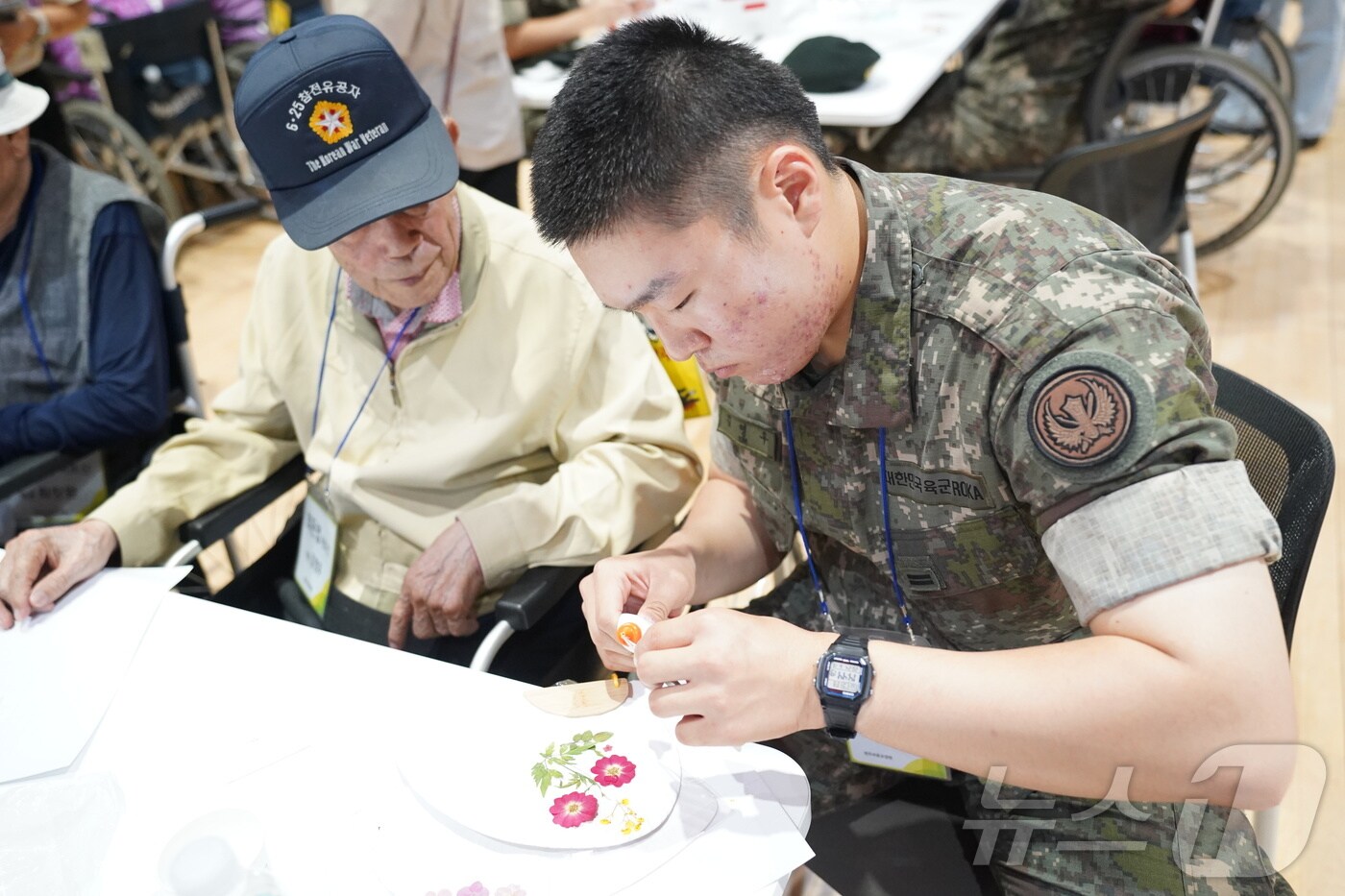 한국보훈복지의료공단 산하 원주보훈요양원이 지난 19일 국립횡성숲체원에서 국가유공자를 비롯한 입소자들에게 항노화 산림치유프로그램을 제공한 가운데, 당시 한 입소자와 봉사에 나선 군 장병이 함께 프로그램에 참여하는 모습. (원주보훈요양원 제공) 2024.6.25/뉴스1