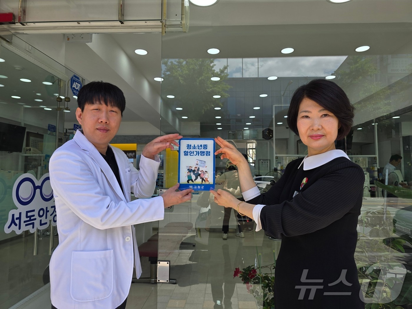 고창군이 청소년증 할인가맹점과 협약을 맺고 협약업체에 가맹점 표지판을 부착했다. 최선임(오른쪽) 인재양성과장이 배준일 서독안경점 대표에게 가맹점 표지판을 전하고 있다.(고창군 제공)2024.6.3/뉴스1 