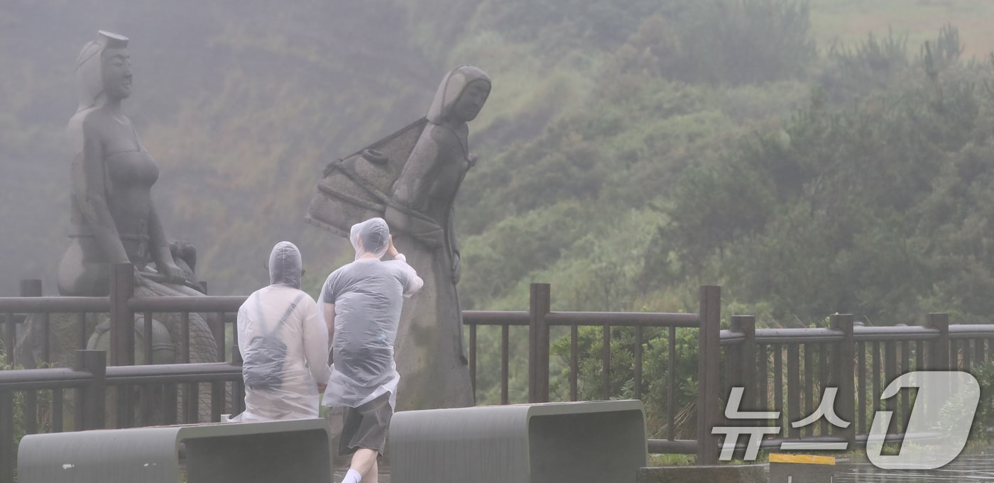 서귀포시 대정읍 송악산 둘레길에서 관광객들이 우비를 입고 이동하고 있다. 2024.6.30/뉴스1 ⓒ News1 오현지 기자