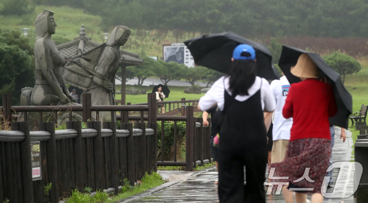 서귀포시 대정읍 송악산 둘레길에서 관광객들이 우산을 쓰고 이동하고 있다. 2024.6.30/뉴스1 ⓒ News1 오현지 기자