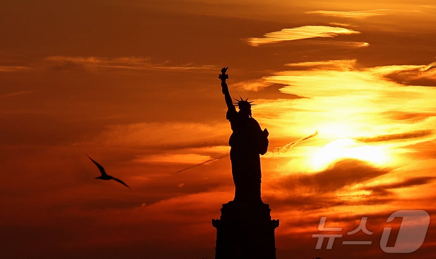 지난달 16일&#40;현지시간&#41; 미국 뉴욕 맨해튼의 명물 &#39;자유의 여신상&#40;Statue of Liberty&#41;&#39;이 일몰로 붉게 노을이 진 모습&lt;자료사진&gt;. 2024.06.16. ⓒ 로이터=뉴스1 ⓒ News1 김성식 기자