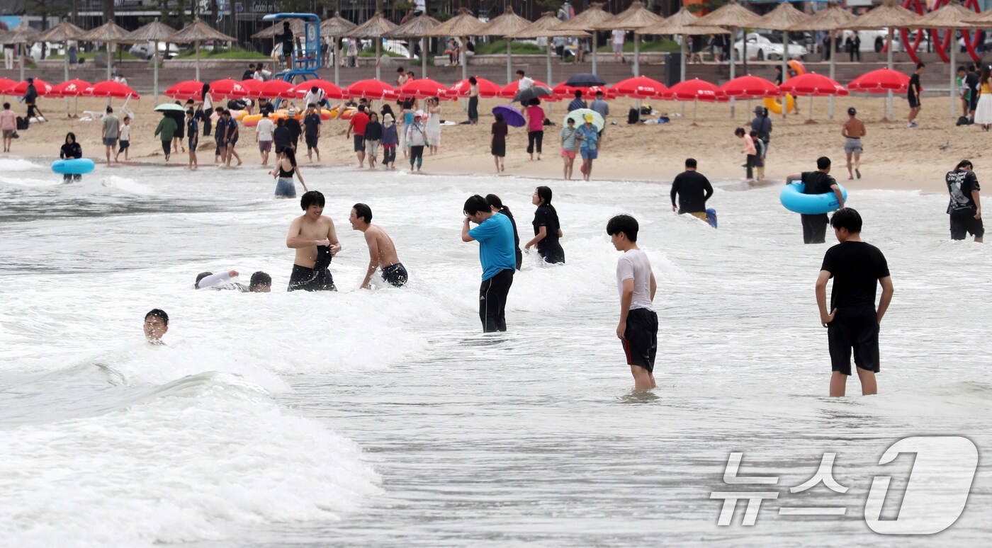 장마가 소강상태를 보이며 무더운 날씨를 보인 19일 오후 부산 수영구 광안리해수욕장을 찾은 학생 등 피서객들이 물놀이를 하며 더위를 식히고 있다. 2024.7.19/뉴스1 ⓒ News1 윤일지 기자