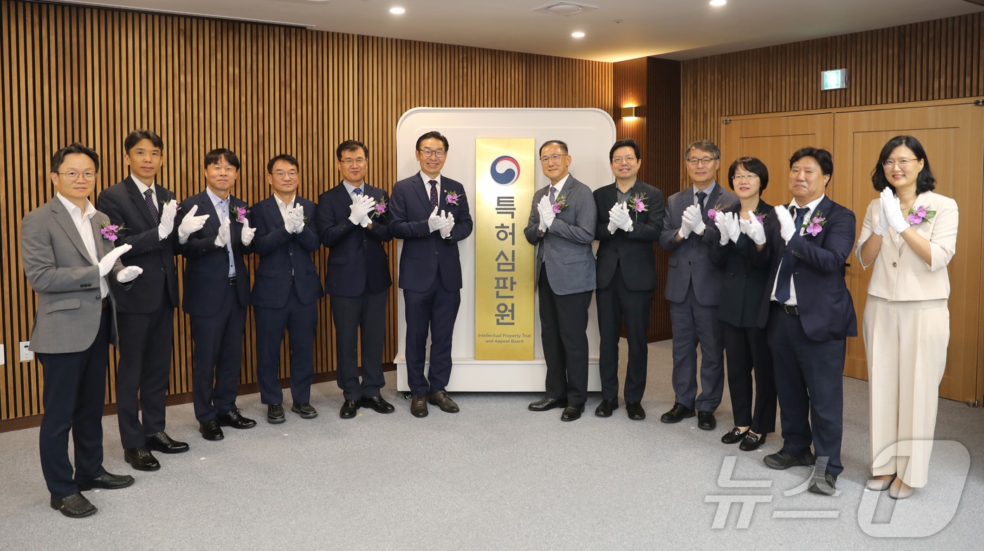 김완기 특허청장(왼쪽에서 6번째)이 현판식을 진행한 후 관계자들과 기념촬영을 하고 있다.(특허청 제공)/뉴스1