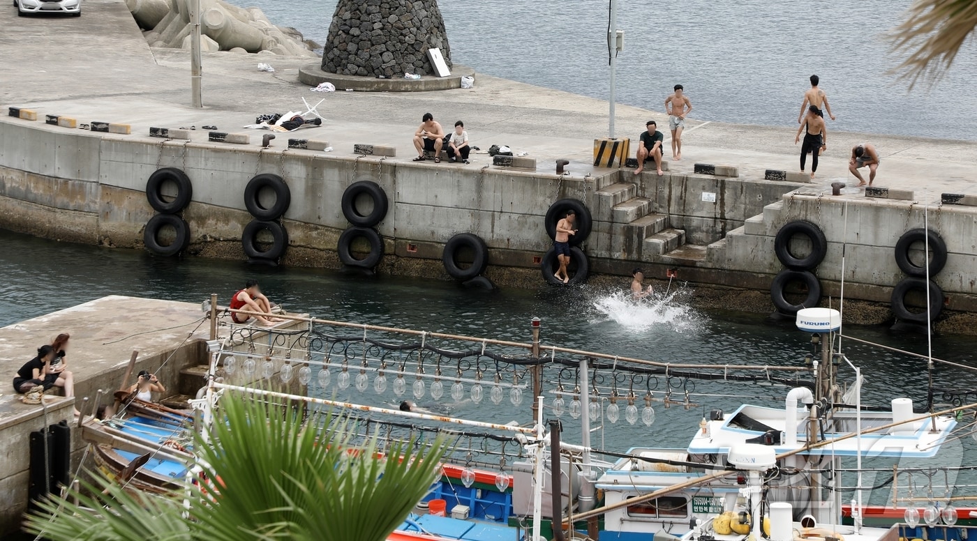 제주시 용담포구에서 사람들이 다이빙을 하며 물놀이를 즐기고 있다. 포구는 수영 등 물놀이가 금지된 곳이다.2024.7.7/뉴스1 ⓒ News1 홍수영 기자