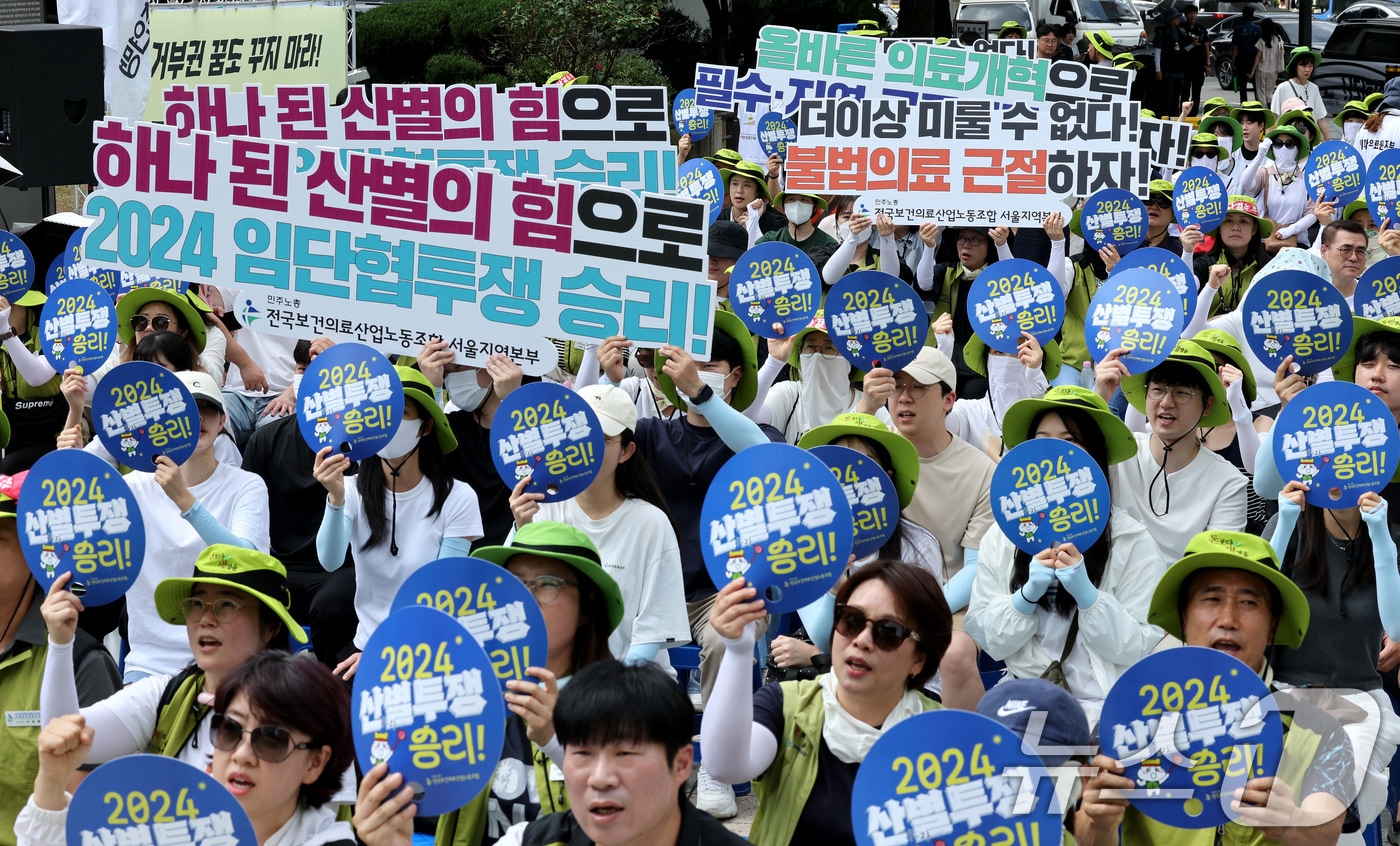 민주노총 전국보건의료산업노조 서울지역본부 조합원들이 12일 오전 서울 종로구 보신각 앞에서 열린 &#39;올바른 의료개혁 쟁취! 2024 산별임단협 투쟁 승리! 보건의료노조 결의대회&#39;에서 구호를 외치고 있다. 노조는 정부가 의정갈등에만 매몰될 것이 아니라 보건 의료 인력 기준 마련 및 업무 범위 명확화, 공공병원 역량 강화 등을 통해 올바른 의료개혁을 위한 제도 개선에 나서야 한다고 목소리를 높였다. 2024.8.12/뉴스1 ⓒ News1 장수영 기자