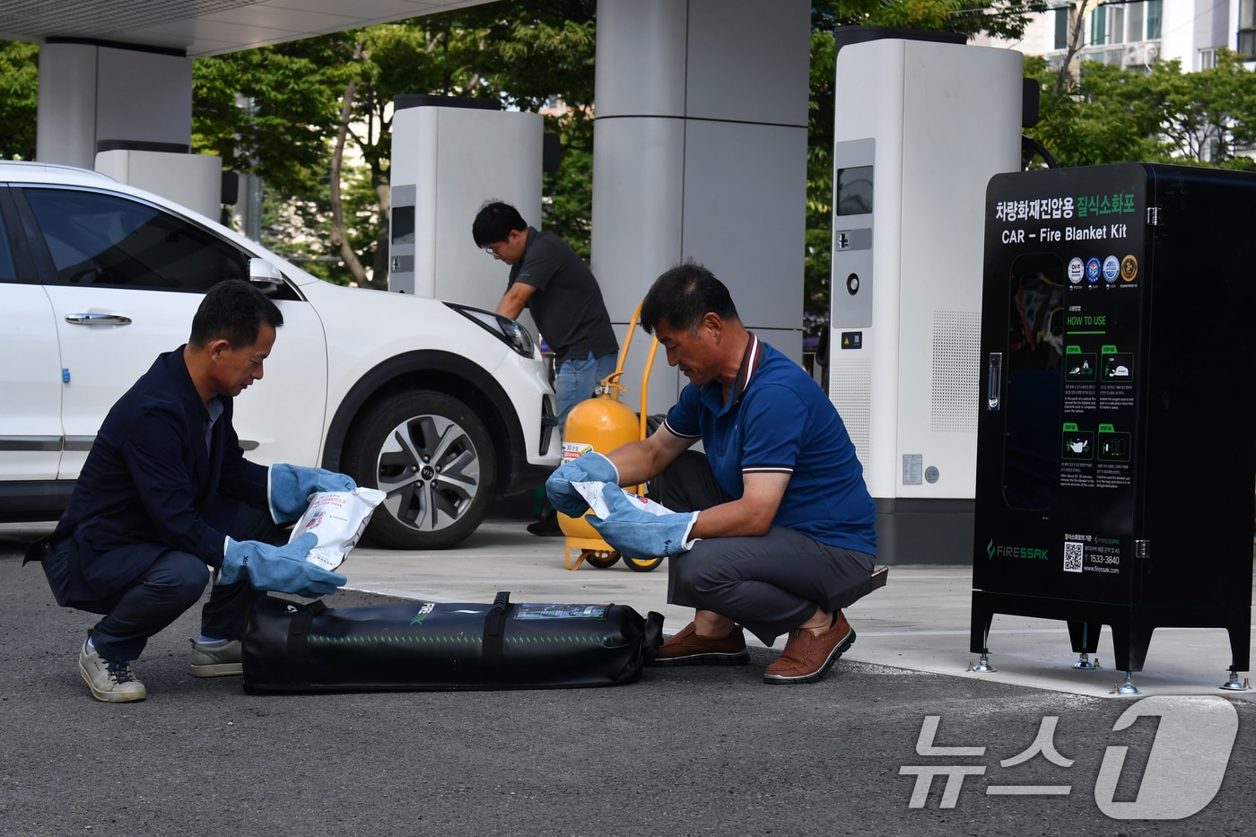 포항시설관리공단 직원들이 지난 8월13일 포항야구장 앞 전기차충전소에서 전기차 화재에 대비해 설치한 질식소화포를 점검하고 있다.2024.8.13/뉴스1 ⓒ News1 최창호 기자