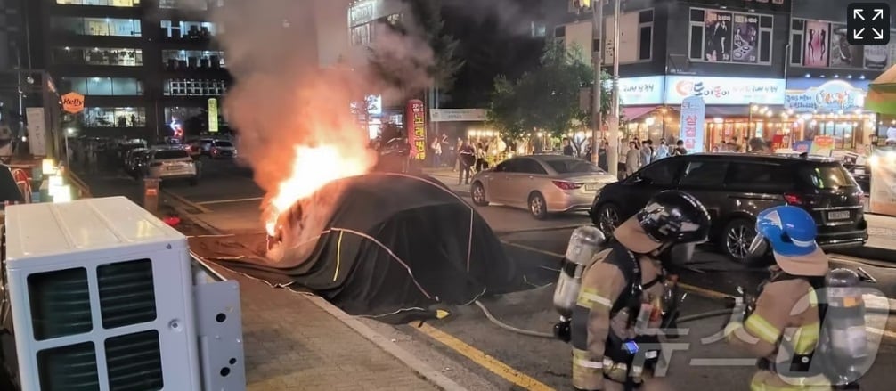 경기도의회 이상원 의원(국민의힘·고양7)이 지상주차장에 충전시설·전용주차구역 설치 권고 등을 담은 조례 제정을 추진한다. 사진은 16일 용인시 구갈동 한 도로에 주차된 테슬라에서 화재가 발생함에 따라 소방관들이 질식소화덮개를 활용해 열폭주를 저지하고 있다.(경기도소방재난본부 제공)/