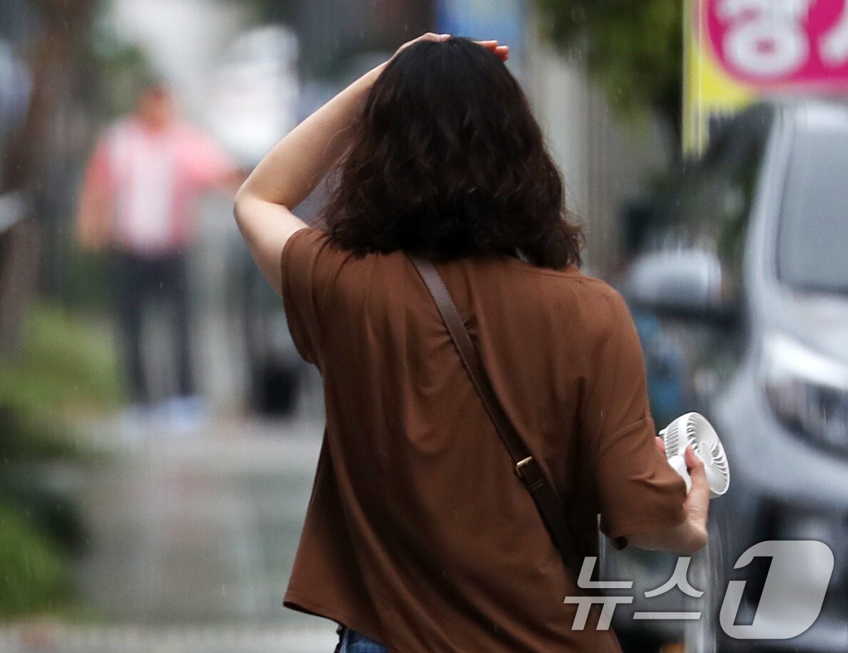 부산 강서구청 인근에서 갑작스러운 소나기가 내린 가운데 우산을 미처 준비하지 못한 시민이 왼손으로 비를 막아보고 있다..2024.8.6/뉴스1 ⓒ News1 윤일지 기자