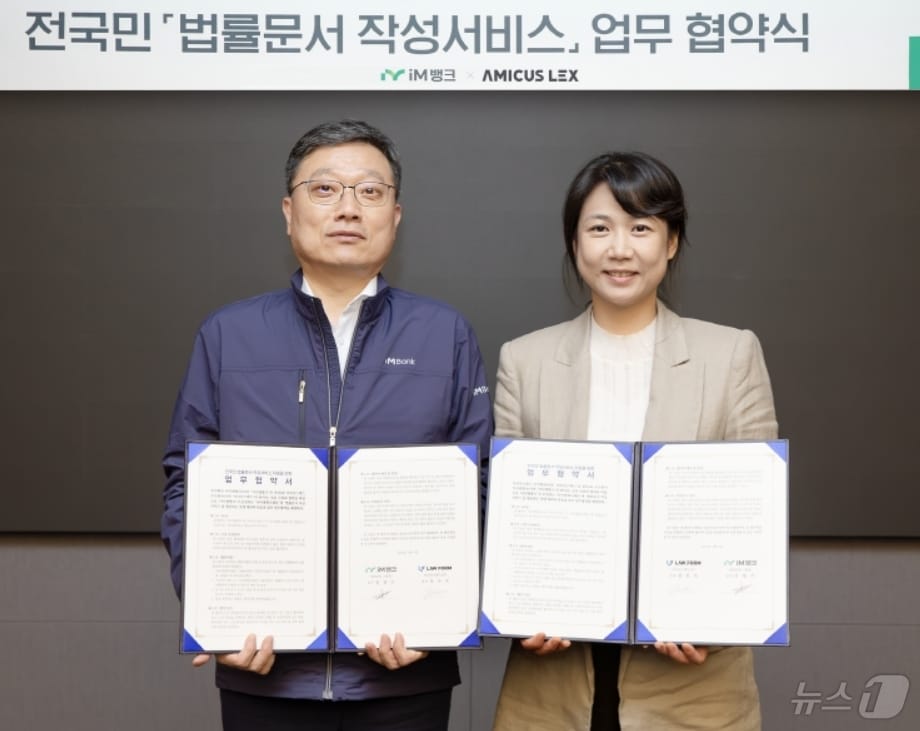 진영수 iM뱅크 그룹장(왼쪽)과 정진숙 아미쿠스렉스㈜ 대표가 9일 법률 문서 작성 서비스 지원을 위한 협약을 체결한 뒤 협약서를 펼쳐 보이고 있다.(iM뱅크 제공)