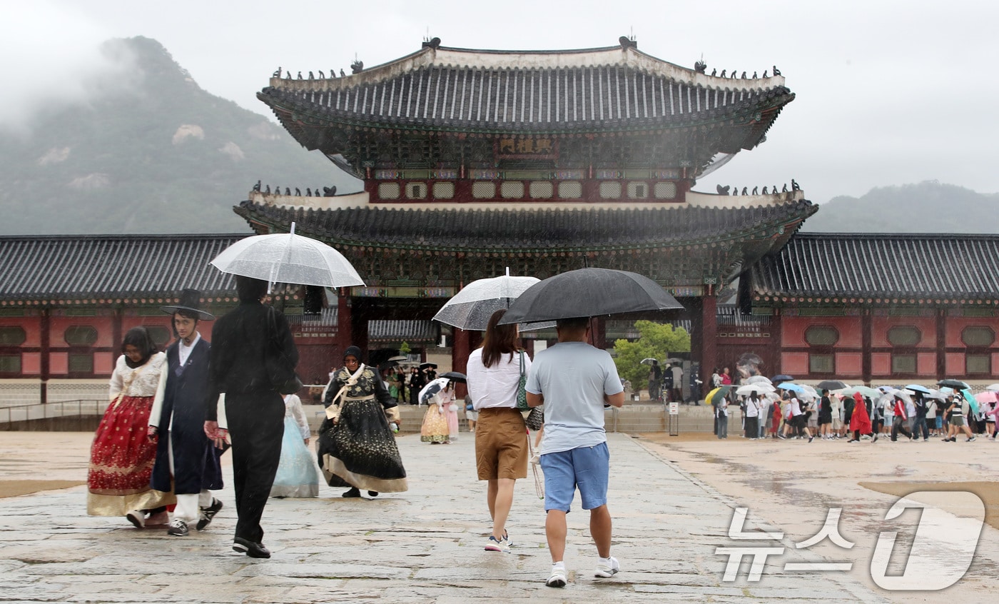 비가 내리는 12일 오후 한복을 입고 서울 종로구 경복궁을 찾은 외국인 관광객이 우산을 쓰고 이동하고 있다. 2024.9.12/뉴스1 ⓒ News1 박세연 기자