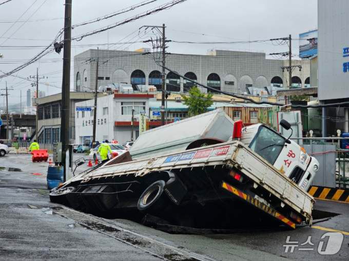 21일 오전 8시45분께 부산 사상구 한 도로에서 가로 10m, 세로 5m, 깊이 8m 가량의 대형 땅꺼짐 현상(싱크홀)이 발생해 도로에서 배수 지원을 하던 삼락119안전센터 배수 차량과 5톤 트럭이 빠져있다. (부산소방재난본부 제공) 2024.9.21/뉴스1 ⓒ News1 윤일지 기자