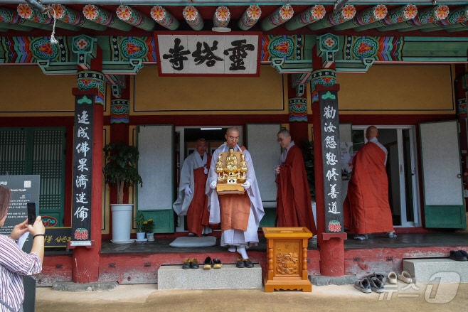 지난 22일 당진 영탑사에서 금동비로자나불삼존좌상이 이운되고 있다. &#40;당진시 제공&#41; / 뉴스1