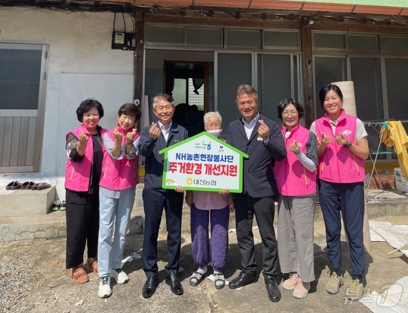   농협 대전본부 및 북대전농협 임직원과 자원봉사자들이 돌봄 어르신의 노후 주택에서 주거환경 개선 봉사활동을 진행한 후 기념사진을 촬영하고 있다.&#40;농협 대전본부 제공&#41;/ 뉴스1 