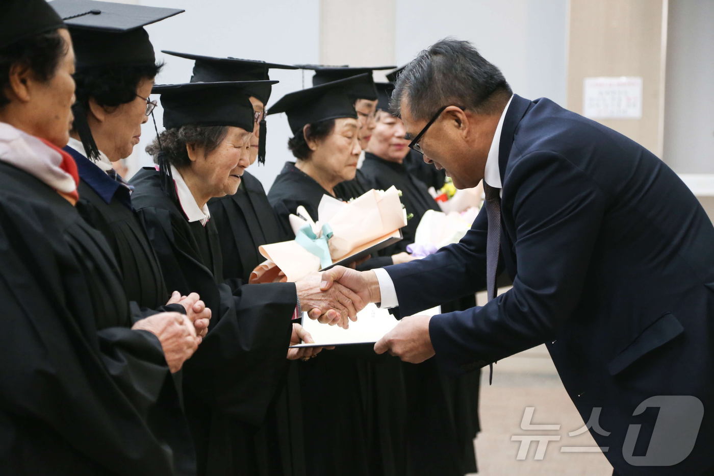 김기웅 서천군수(오른쪽)가 초·중 학력을 인정받은 문해교육 수료생들과 기념촬영을 하고 있다.(서천군 제공)/뉴스1