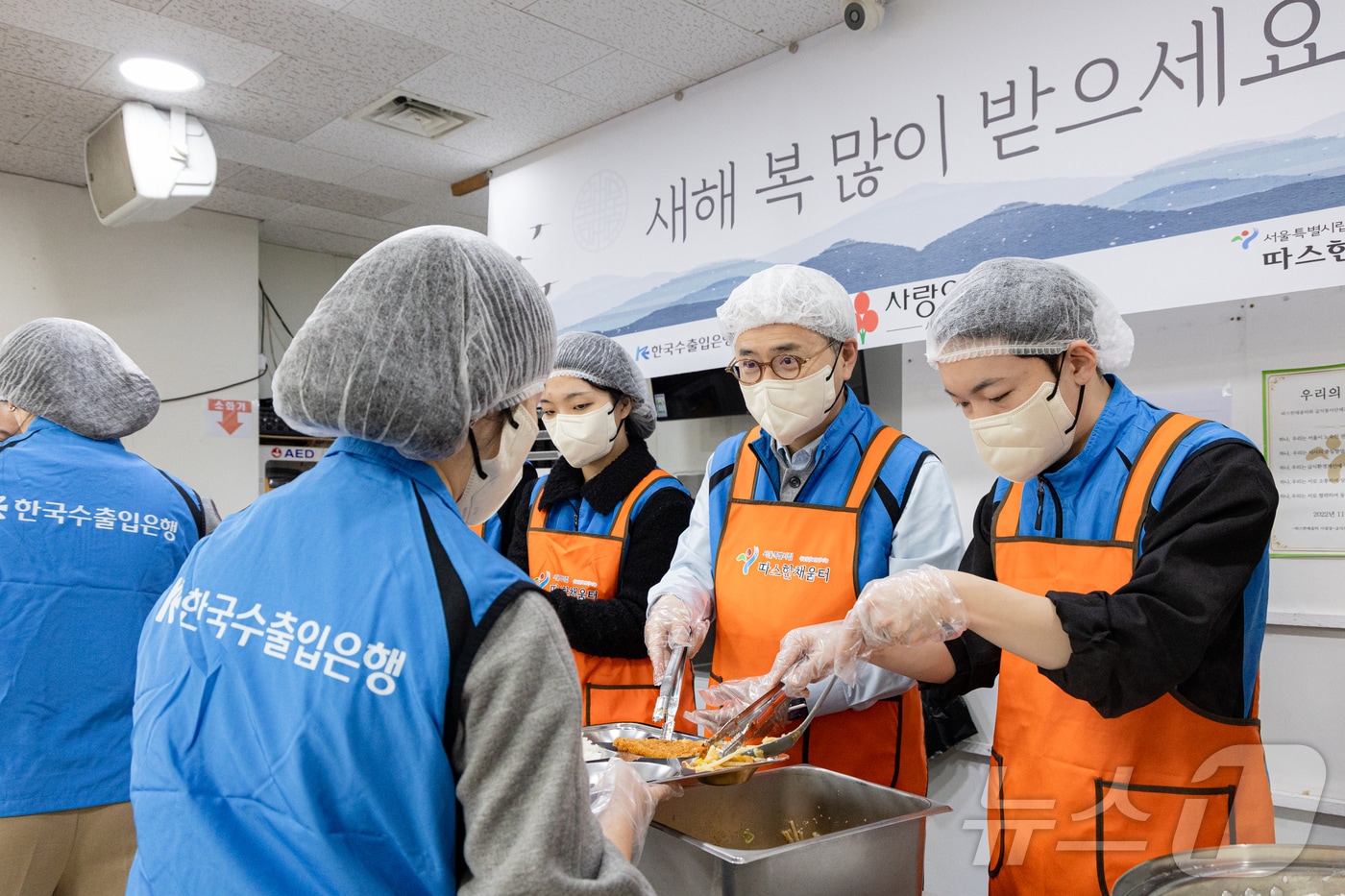 윤희성 수출입은행장(사진 오른쪽 두번째)을 비롯한 수은 본점 임직원들이 14일 오전 서울역 인근에 있는 노숙인 대상 무료 급식소에서 봉사활동을 하고 있다.(수은 제공)