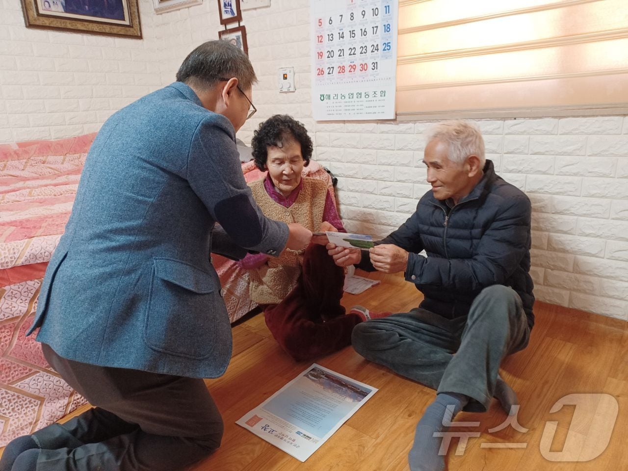  고창군이 75세 이상 어르신에게 설 명절 전에 ‘경로 목욕 및 이‧미용비 지원금’을 지급한다. 해리면 직원이 어르신에게 상품권을 전하고 있다.(고창군 제공)2025.1.21/뉴스1