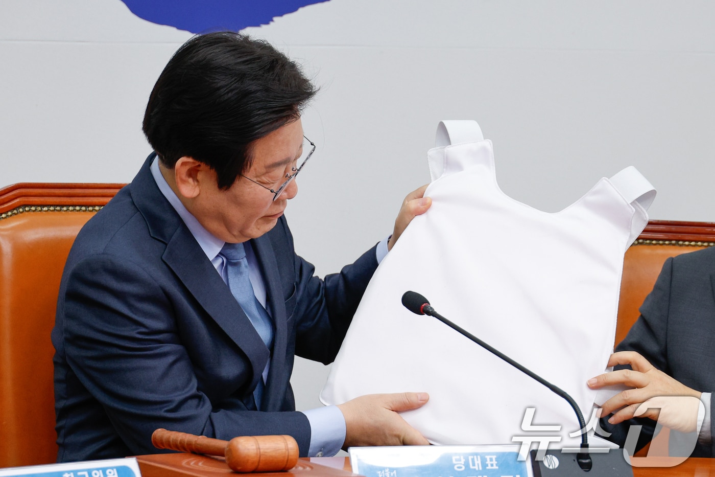 이재명 더불어민주당 대표가 22일 오전 서울 여의도 국회에서 열린 최고위원회의에 참석해 김병주 최고위원의 민주파출소에 접수된 테러 위협 제보 관련 발언을 들으며 김 최고위원이 가져온 방탄복을 살펴보고 있다. 2025.1.22/뉴스1 ⓒ News1 안은나 기자