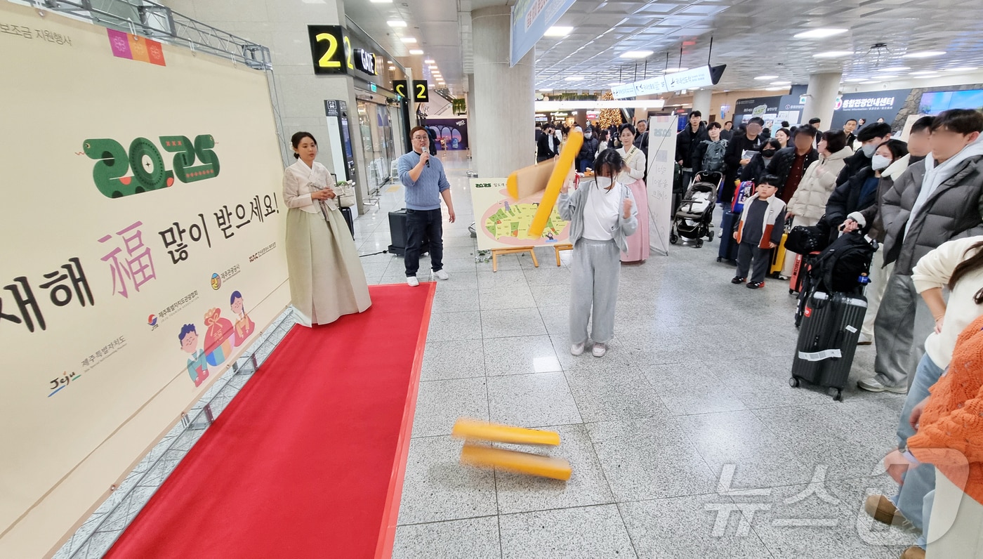 설 연휴를 하루 앞둔 24일 오후 제주국제공항 1층 국내선 도착장 앞에서 설 맞이 윷놀이 이벤트가 진행되고 있다.2025.1.24./뉴스1