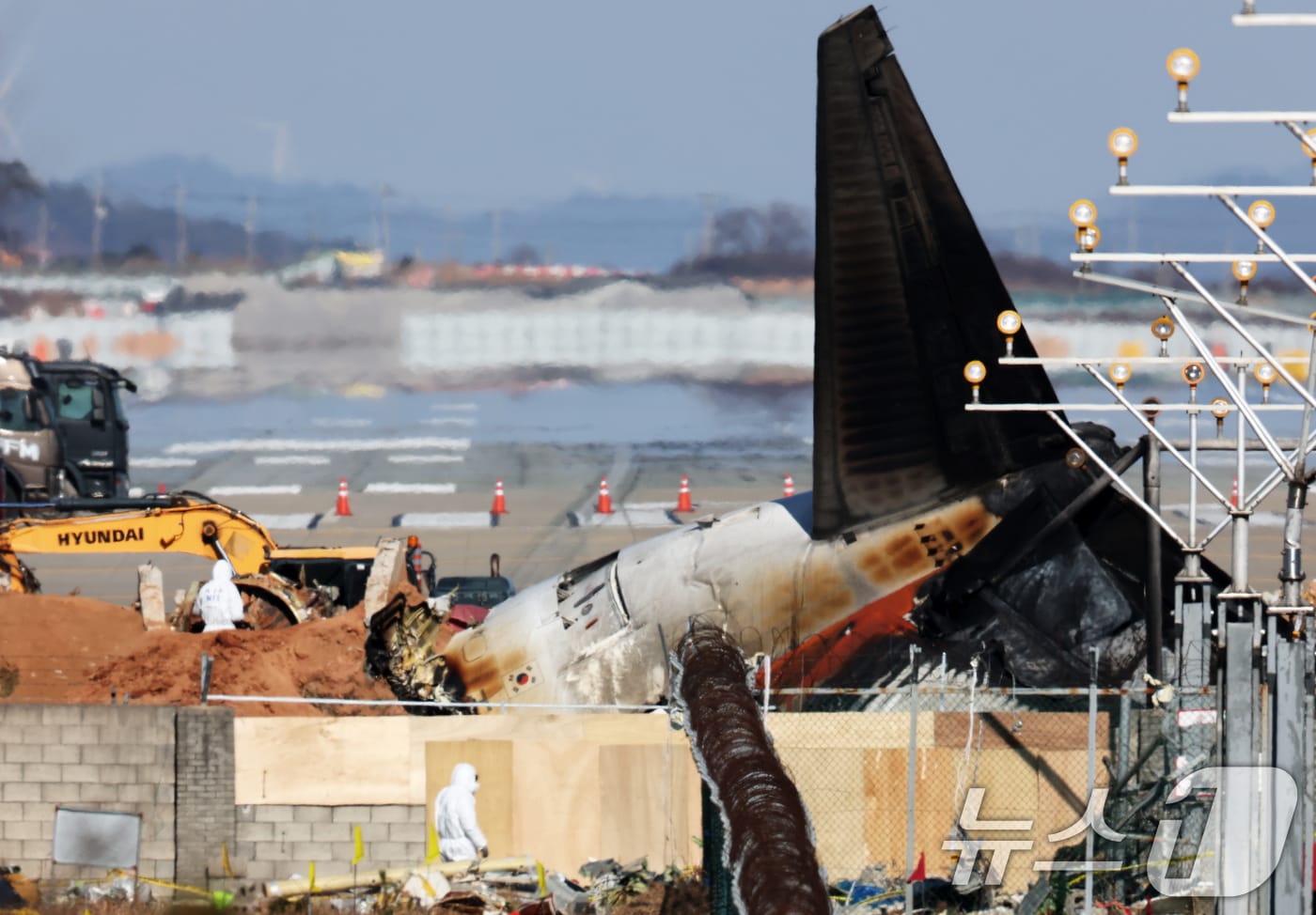 전남 무안국제공항 참사 현장에서 국과수 관계자들이 로컬라이저&#40;방위각시설&#41; 둔덕에 파묻힌 엔진을 살펴보고 있다. 2025.1.3/뉴스1 ⓒ News1 오대일 기자