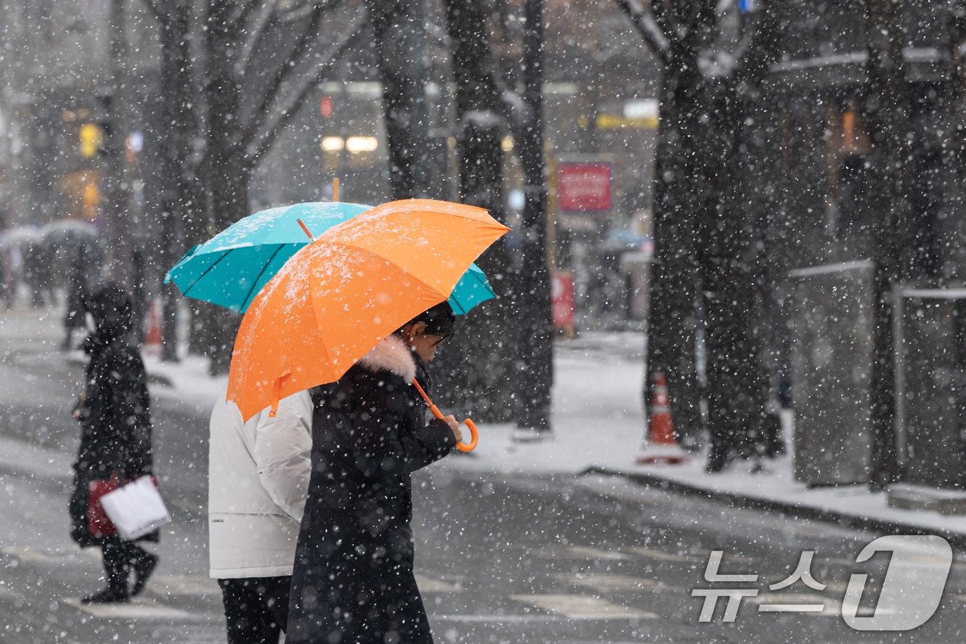 서울을 비롯한 중부지방에 눈이 내리는 31일 오후 서울 중구 청계천 인근에서 우산을 쓴 시민들이 발걸음을 옮기고 있다. 기상청은 이날 서울을 포함한 수도권과 강원, 충북 북부에 최대 5㎝의 눈이 내려 쌓일 것으로 예보했다. 2025.1.31/뉴스1 ⓒ News1 이승배 기자