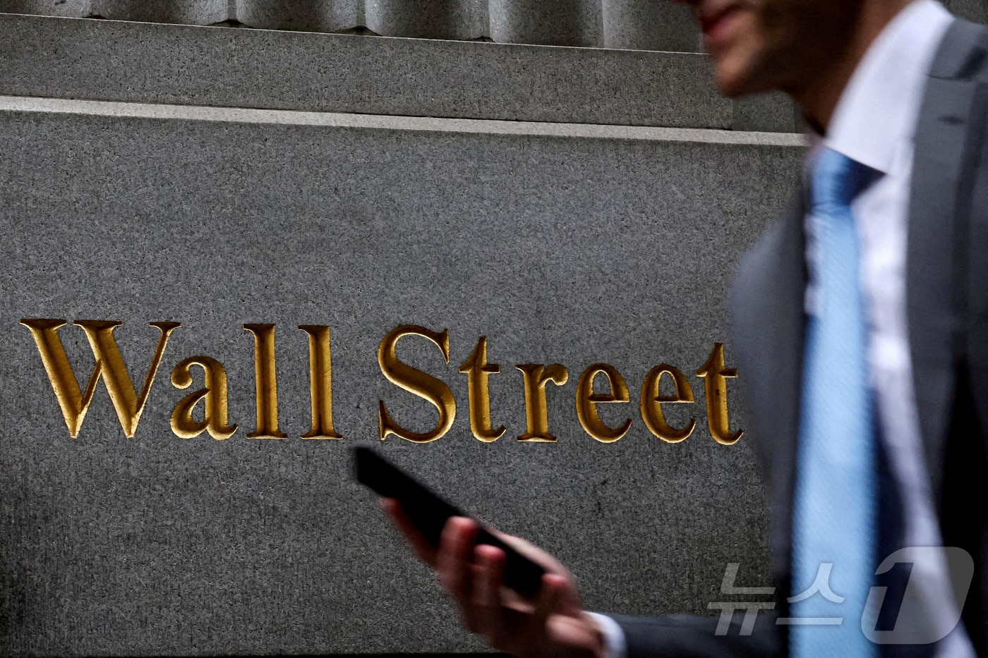 월가 표지판 앞을 지나가는 행인.  ⓒ 로이터=뉴스1