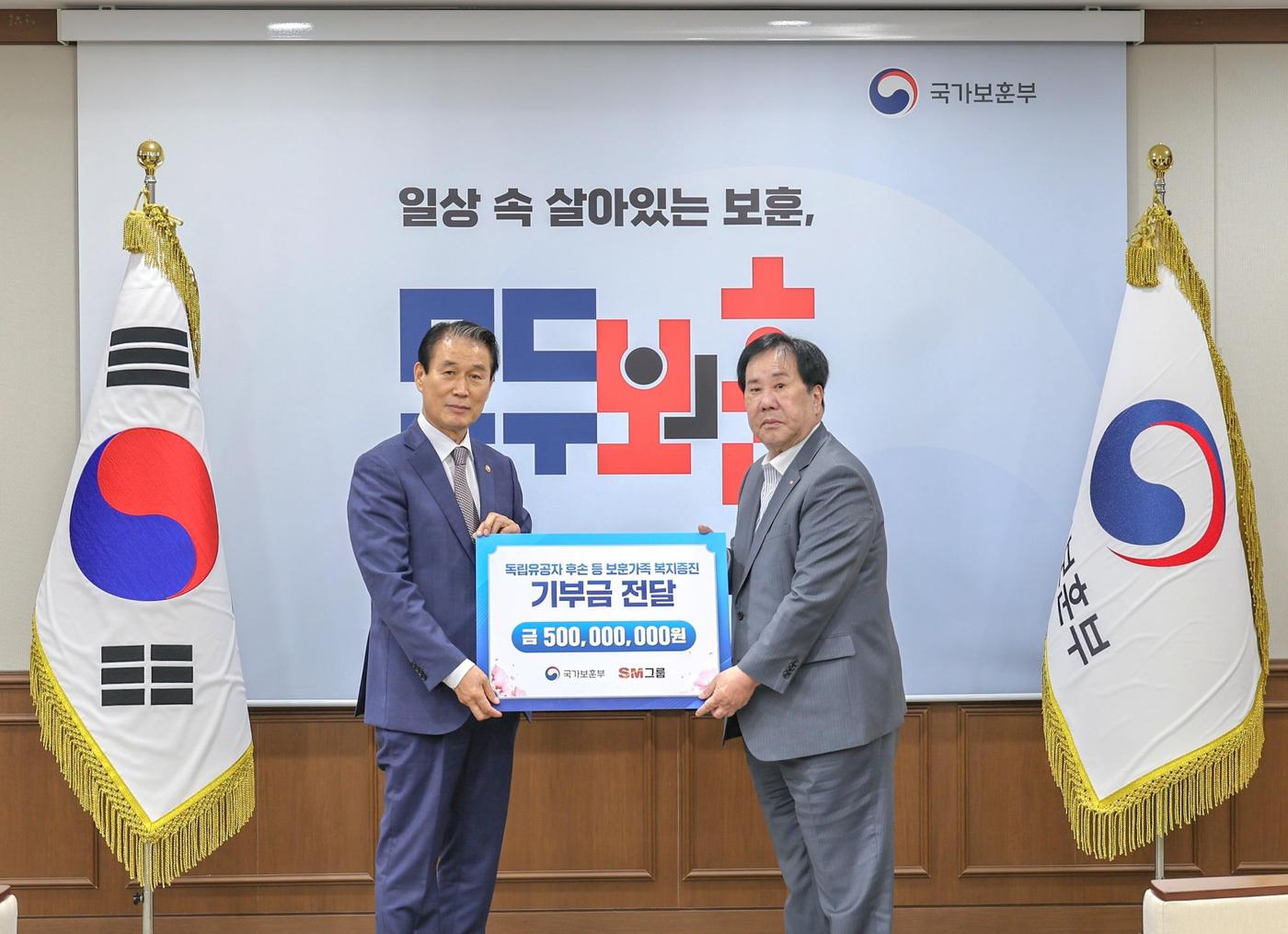 우오현 SM그룹 회장(오른쪽)이 13일 오전 정부세종청사에서 열린 국가보훈부의 전 국민 보훈 기부 프로젝트 '모두의 보훈 드림' 후원금 전달식에서 권오을 장관과 기념촬영을 하고 있다.(SM그룹 제공) 뉴스1 ⓒ News1