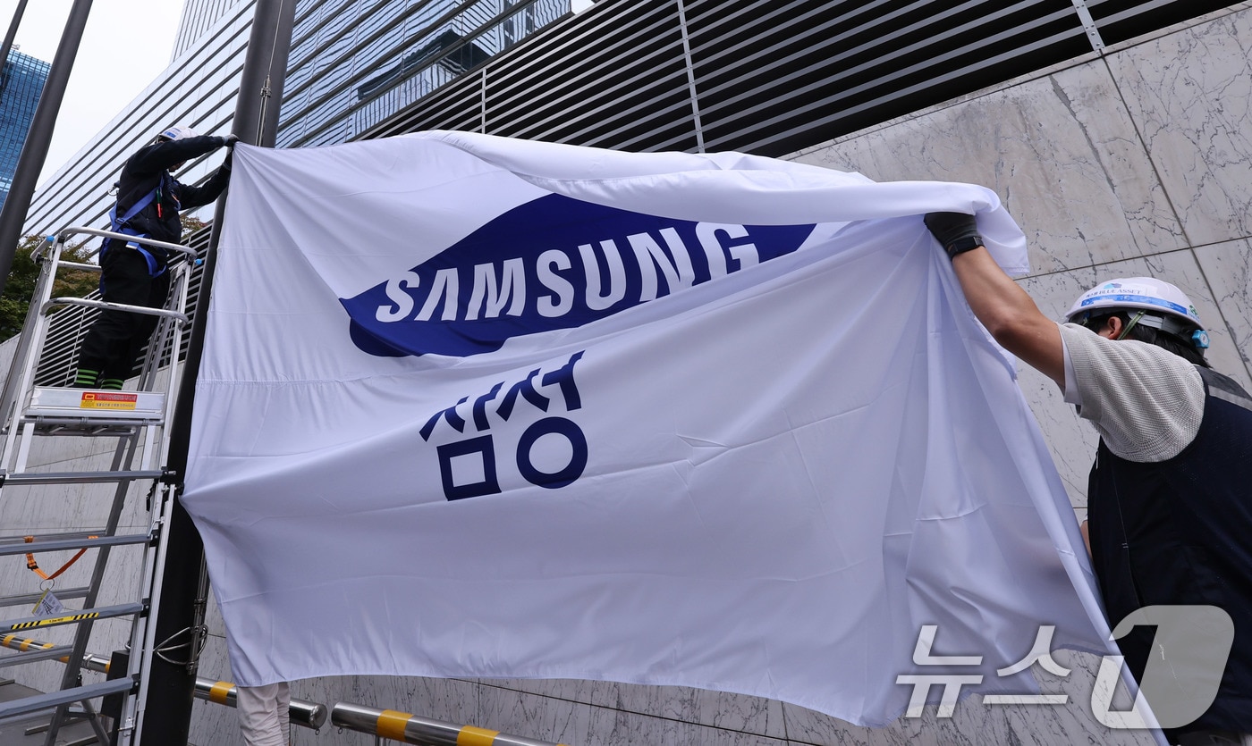 14일 서울 서초구 삼성전자 서초사옥에서 관계자들이 사기를 새 것으로 교체해 게양하고 있다. 이날 삼성전자는 올 3분기 12조 원대의 영업이익을 기록하면서 반등에 성공했다. 매출액은 역대 분기 최고치를 경신했고 &#39;10조 클럽&#39;에 재차 가입했다. 2025.10.14/뉴스1 ⓒ News1 박지혜 기자
